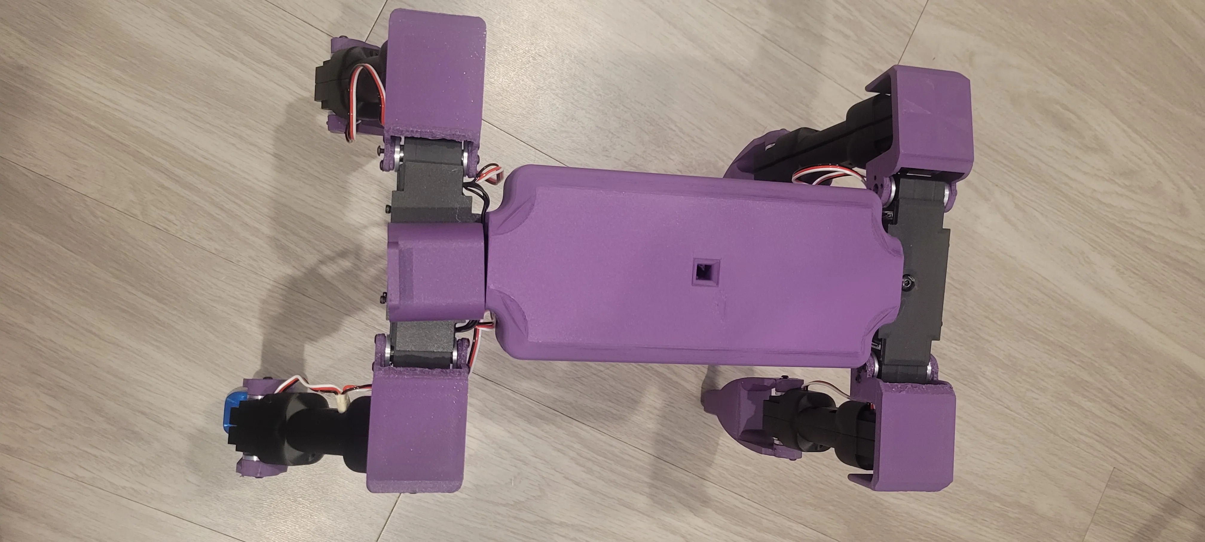 Top-down view of the all-purple next-revision Dog v3 chassis on the workshop floor