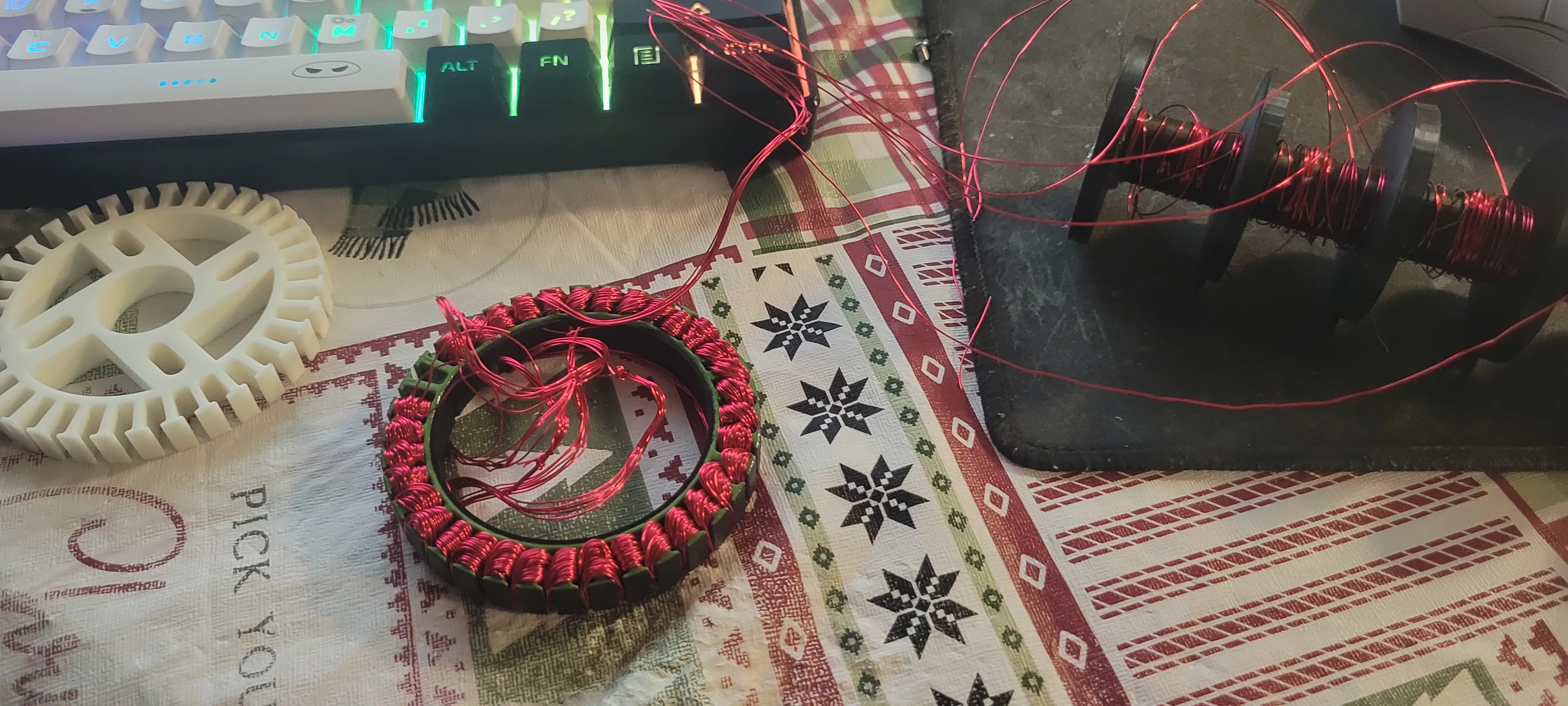 Hand-wound BLDC stator on the workbench with its printed rotor carrier and control electronics